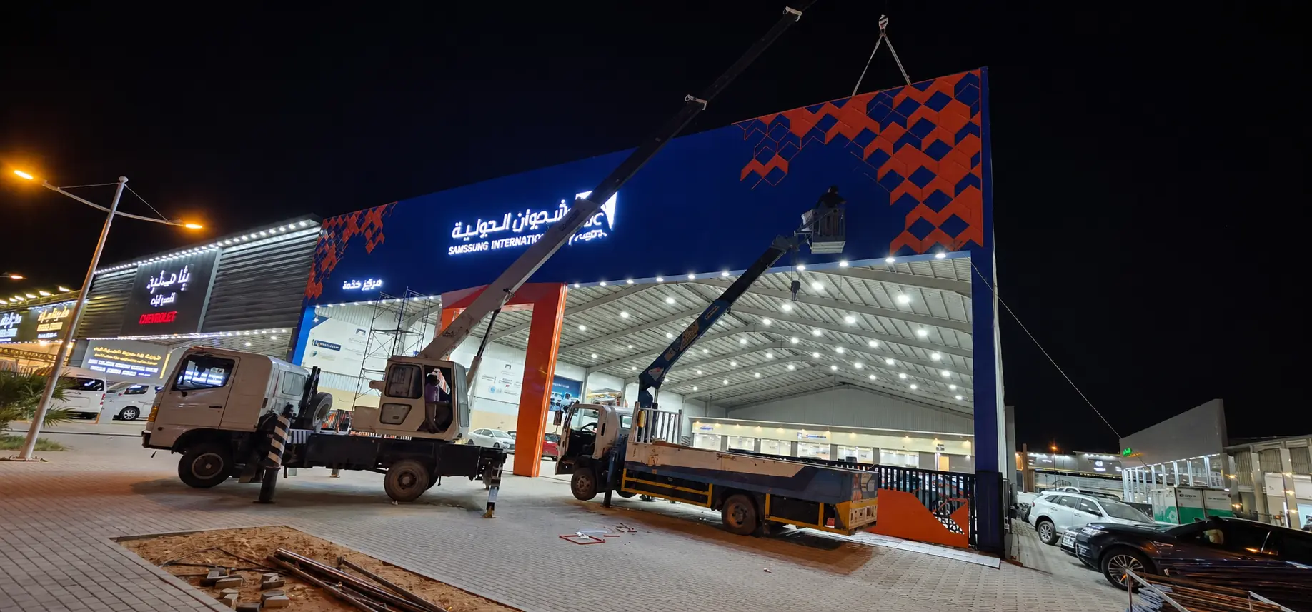 Large-format facade and signage installation at night using access equipment