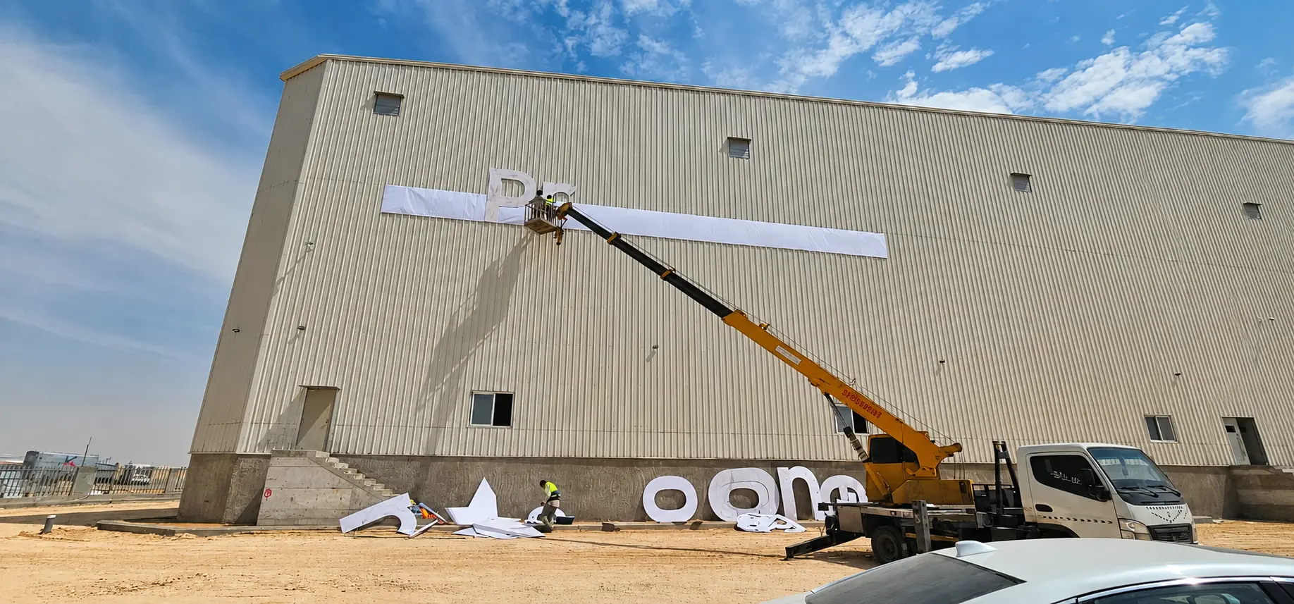 Large-scale industrial signage installation using access equipment